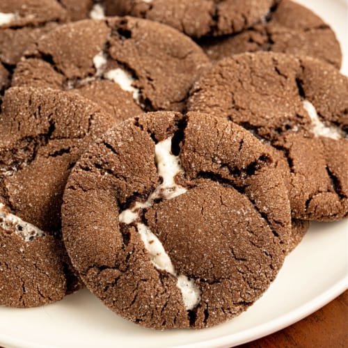 Chocolate cookies willed with marshmallow on a white plate.