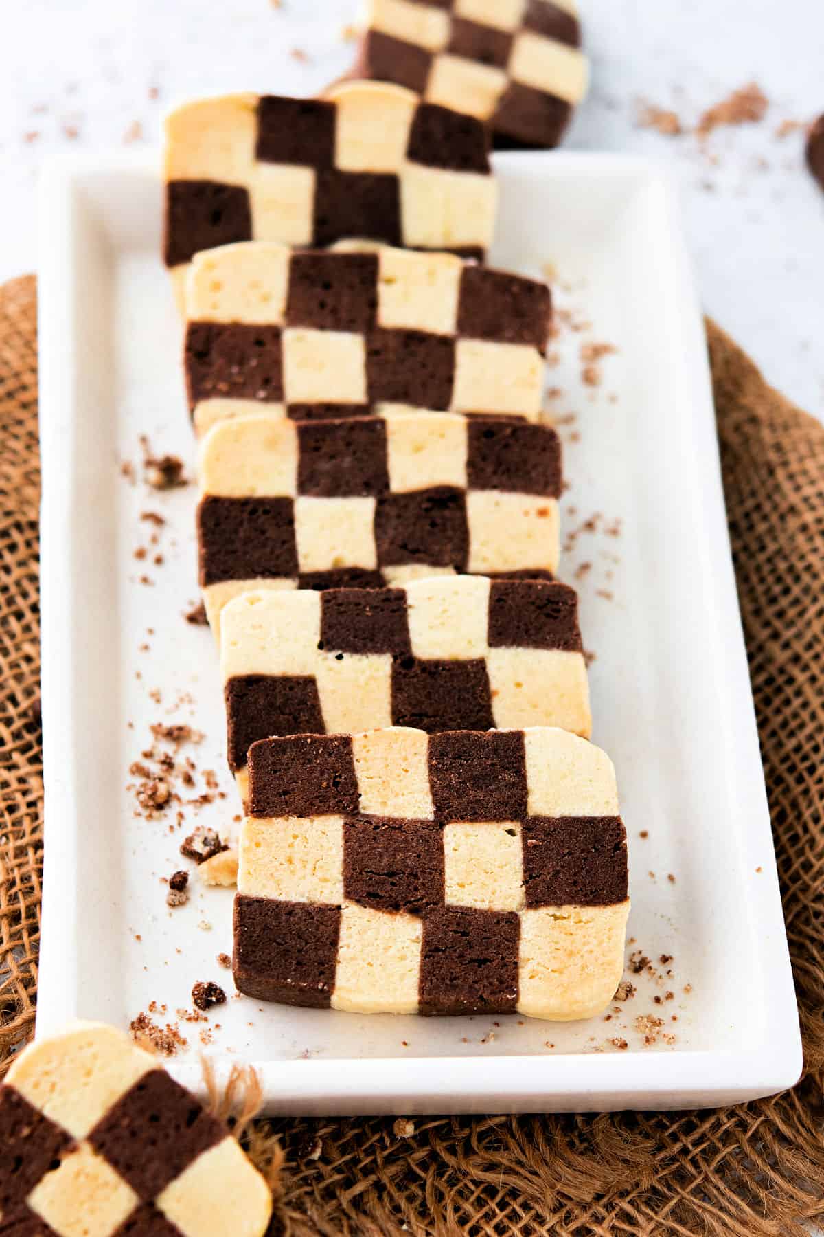 Sliced checkerboard cookies on a white oval plate.