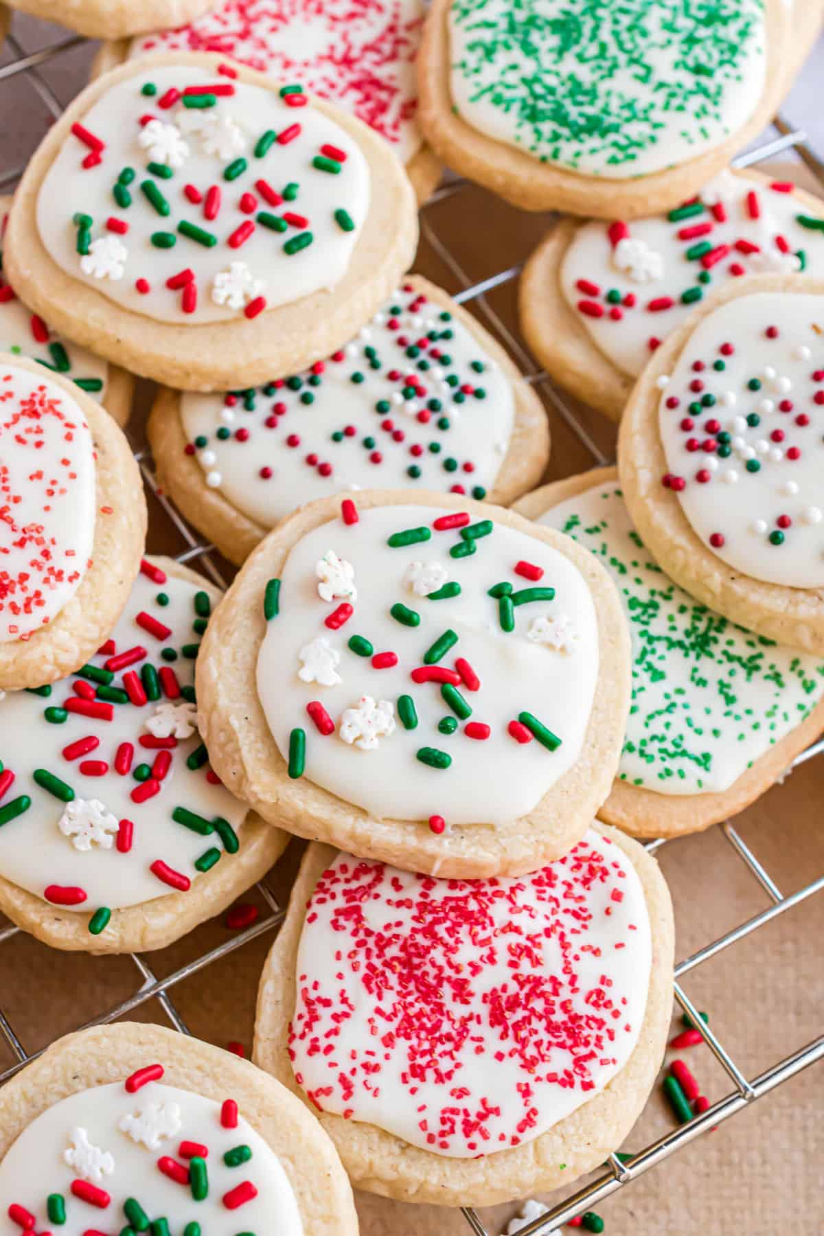 Christmas shortbread cookies stacked on a wire cooling rack.