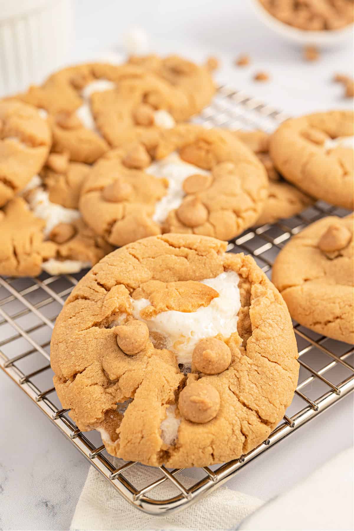Peanut butter cookie with marshmallow on a wire cooling rack.