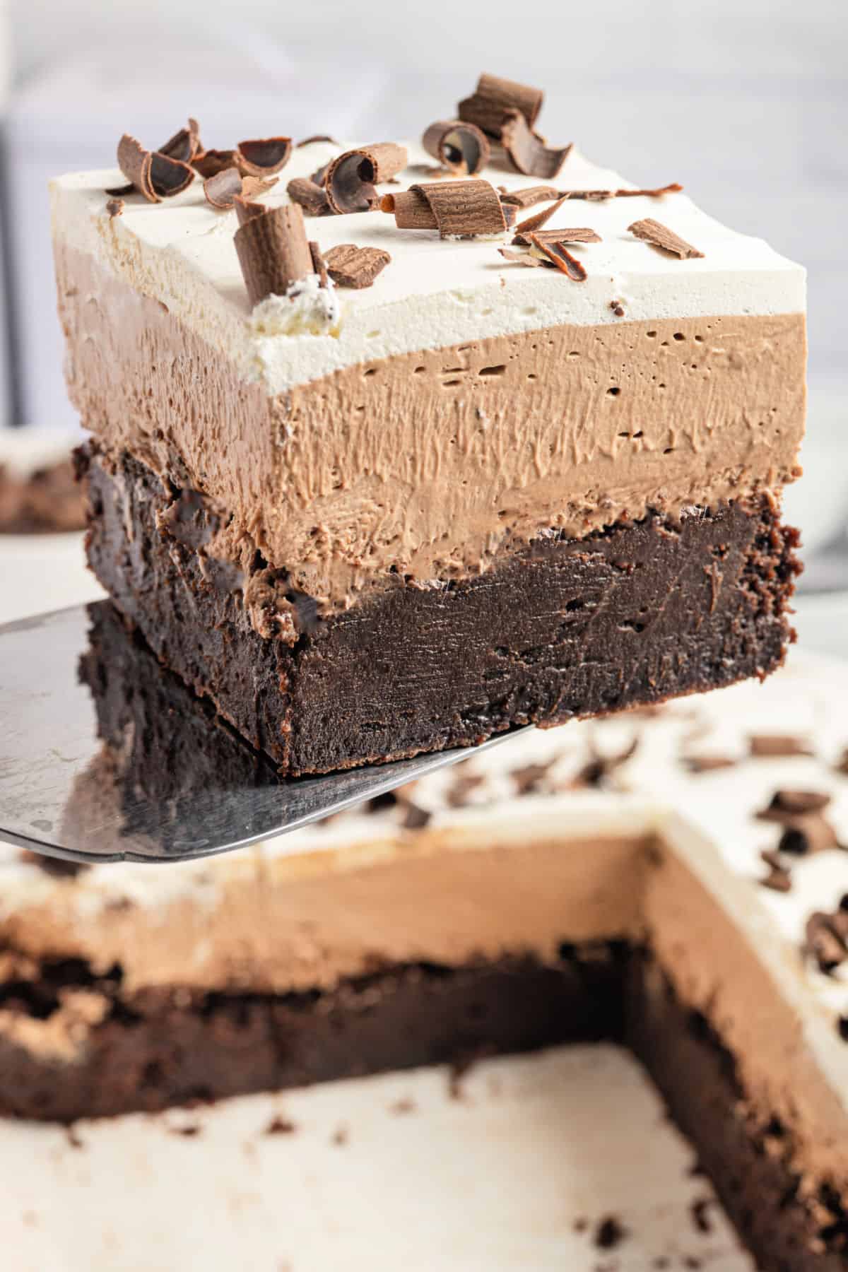 Slice of french silk brownies being lifted out of baking pan.