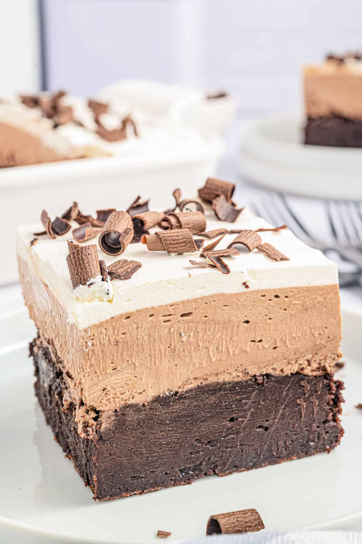 Slice of layered french silk brownie on a white plate.