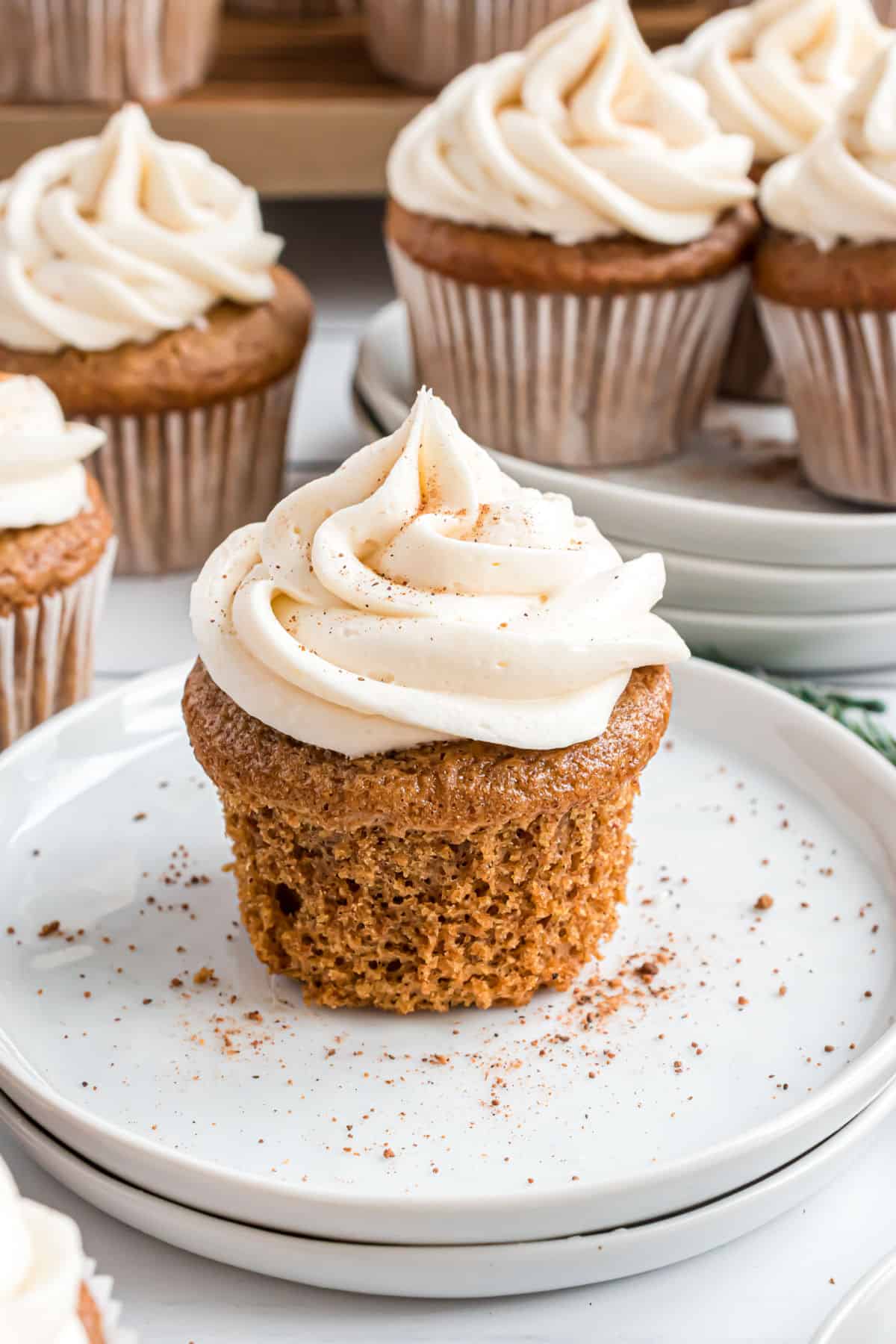 Cupcake on a stack of white plates with cupcake liner removed.