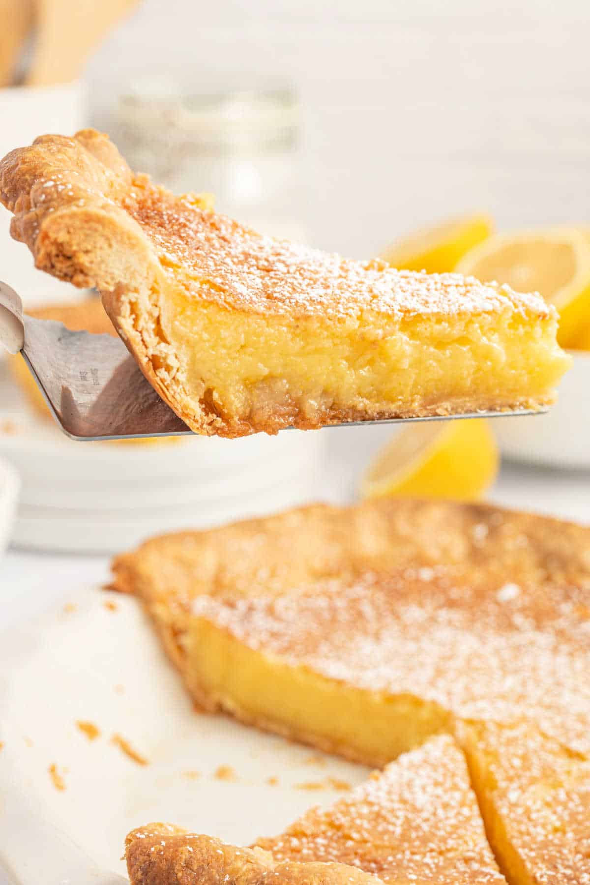 Slice of lemon custard pie being lifted out of pie plate.