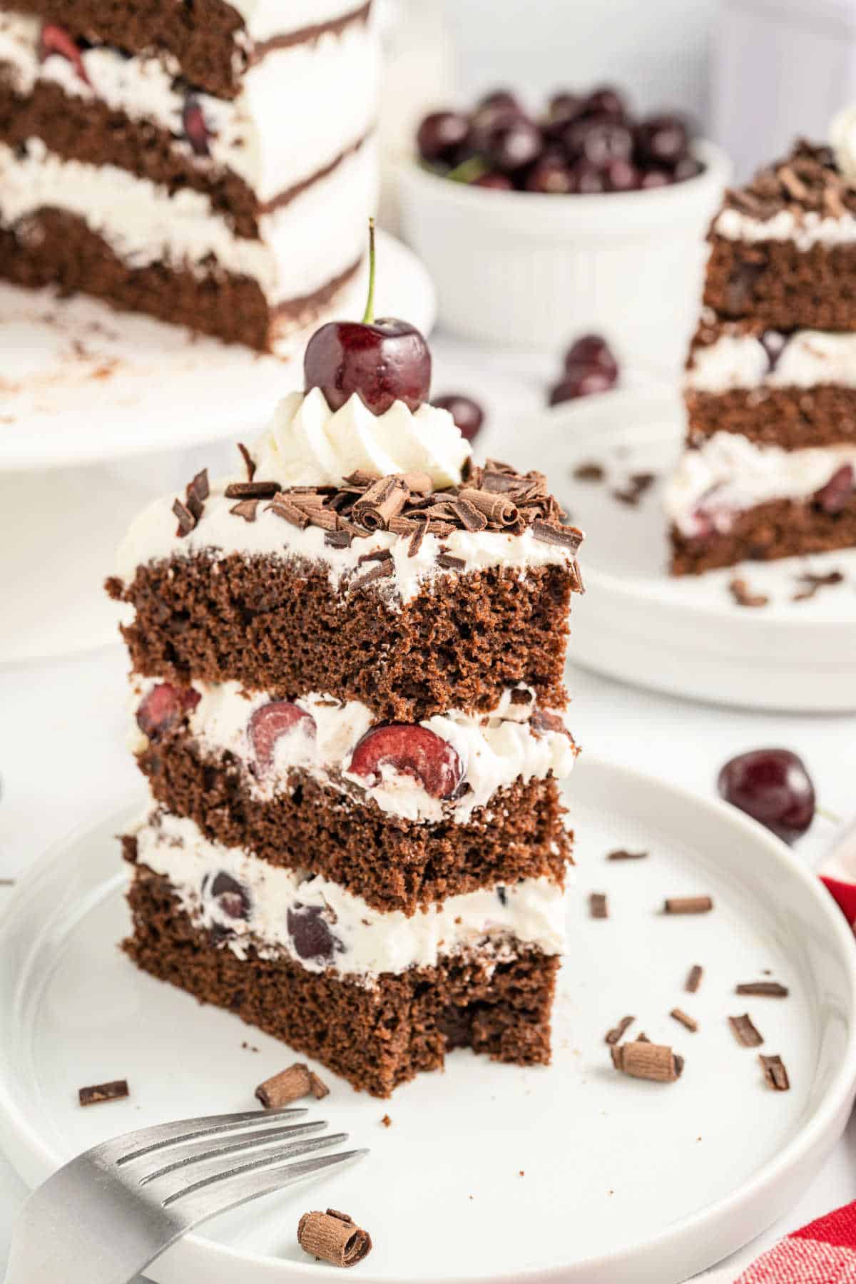 Slice of black forest cake with a bite taken out.