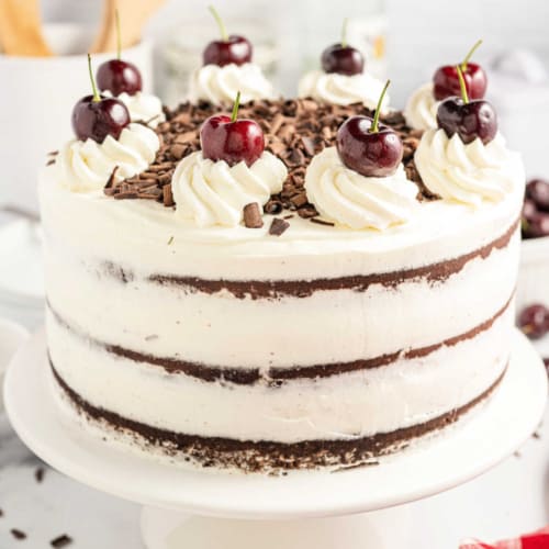 This Black Forest Cake recipe combines rich chocolate cake, fluffy whipped cream, and cherries for a show-stopping dessert. Top it with chocolate shavings and fresh whipped cream for an unforgettable cake. 