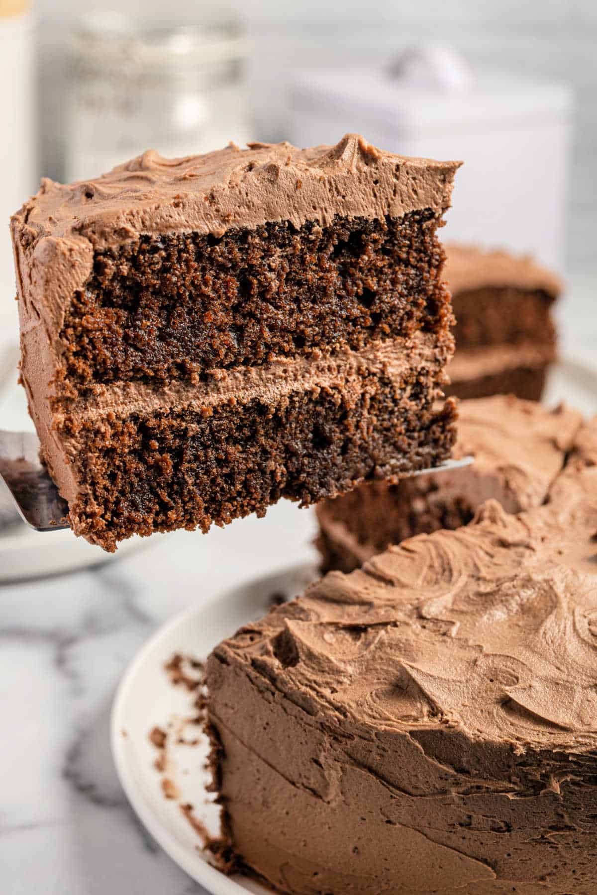 Slice of chocolate layer cake being lifted with a spatula.