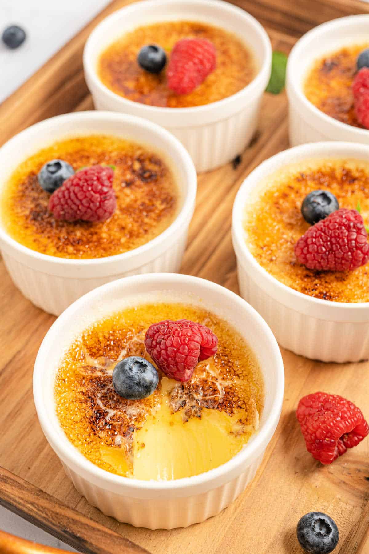 Ramekins with creme brulee topped with berries.