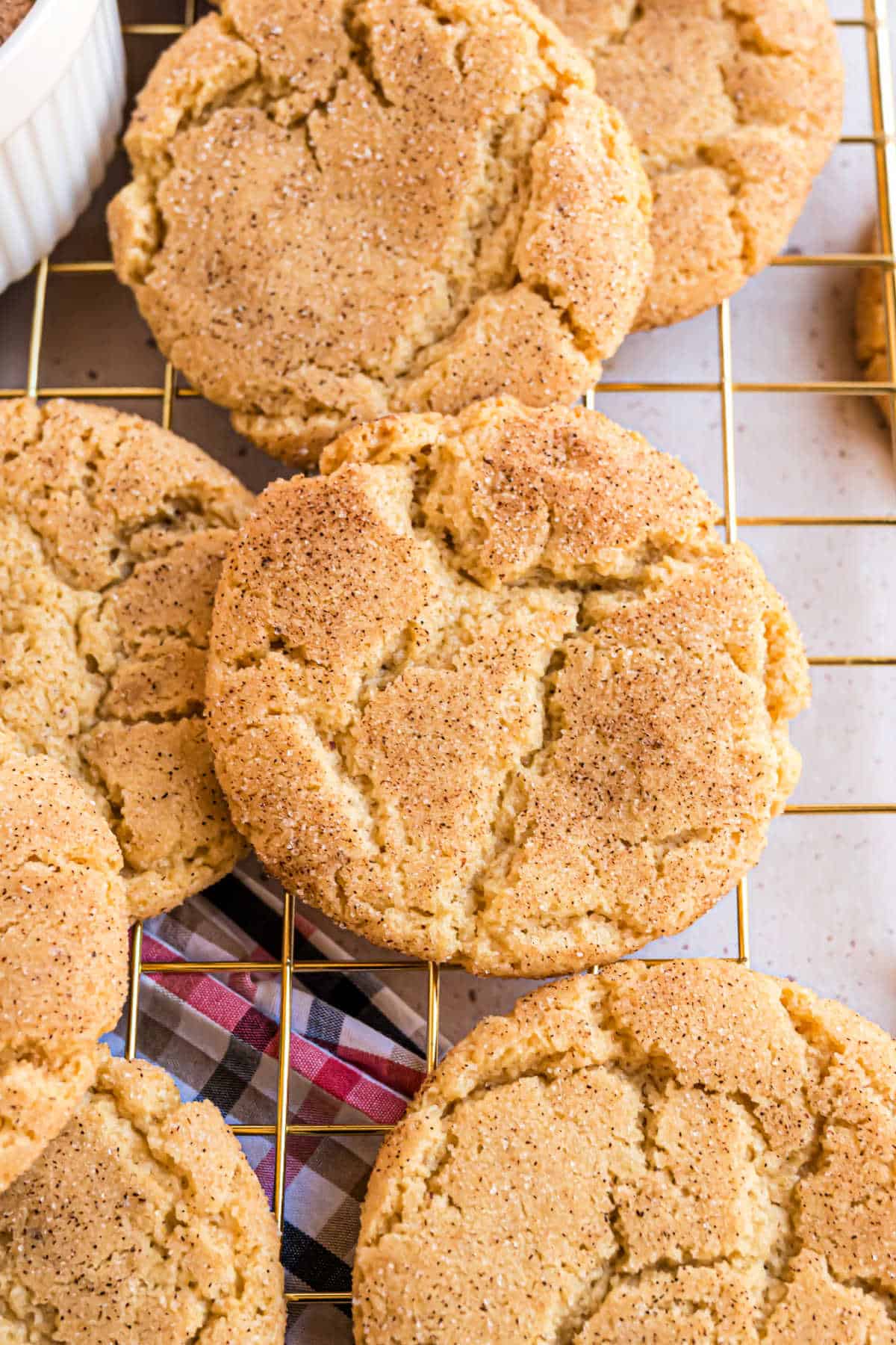 Snickerdoodle cookies stacked on a wire cooling rack.