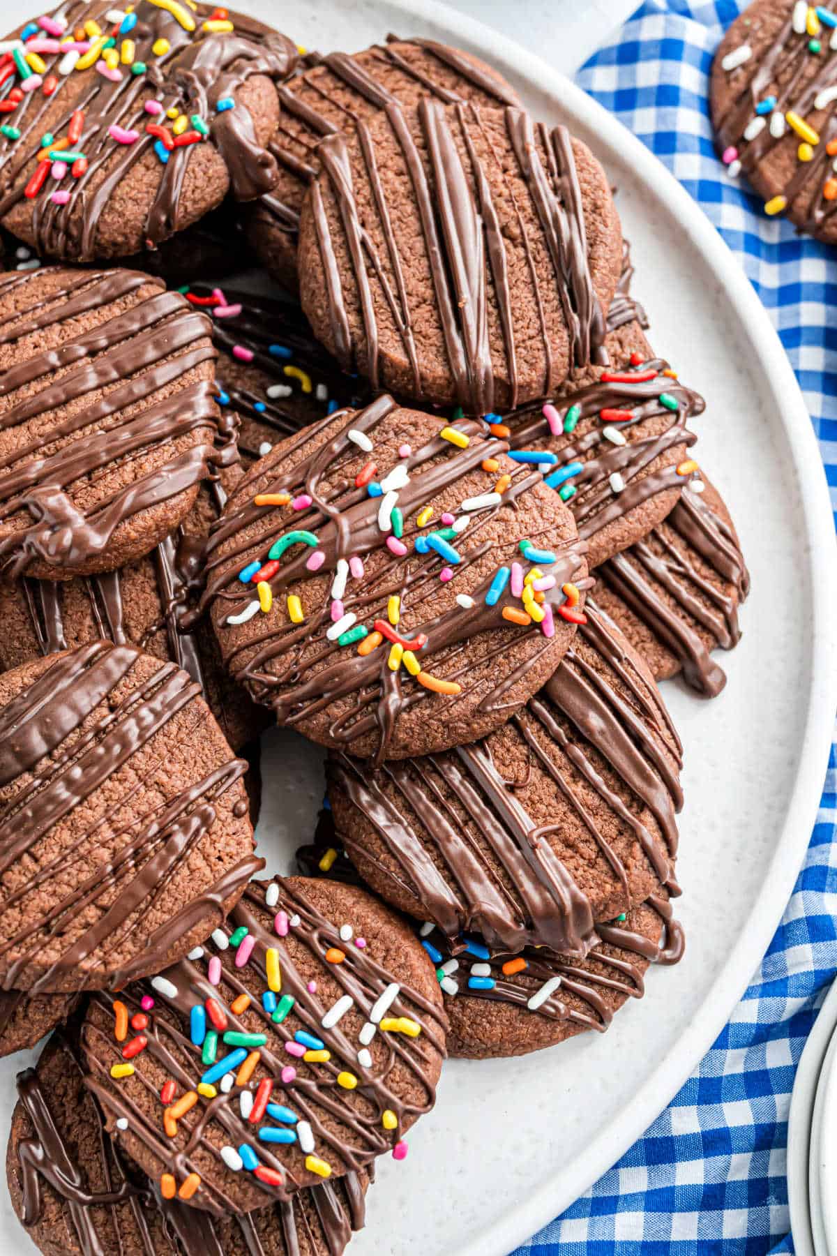 Chocolate shortbread cookies stacked on a white serving plate.