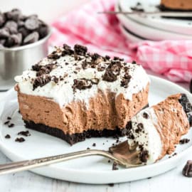 Slice of a chocolate cheesecake with a bite taken out on a fork.