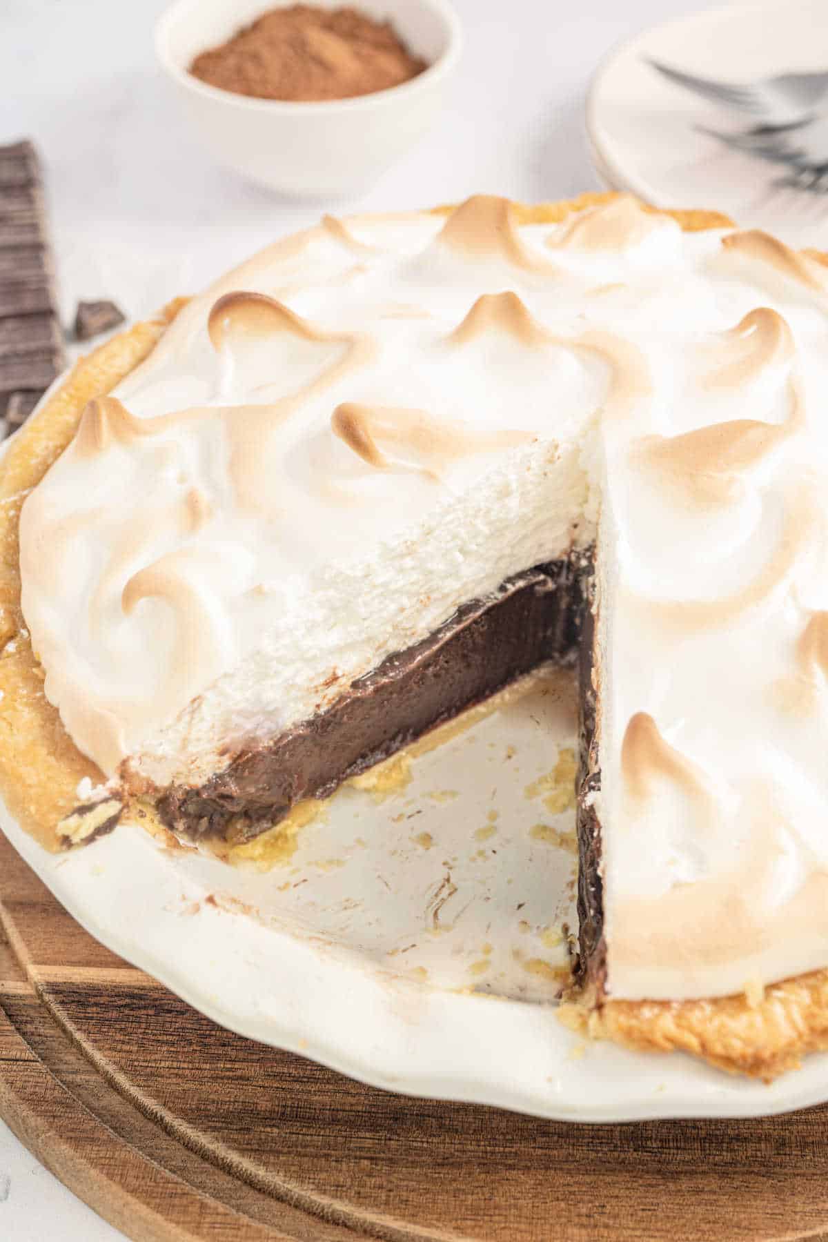 Chocolate pie with meringue topping and a slice removed.