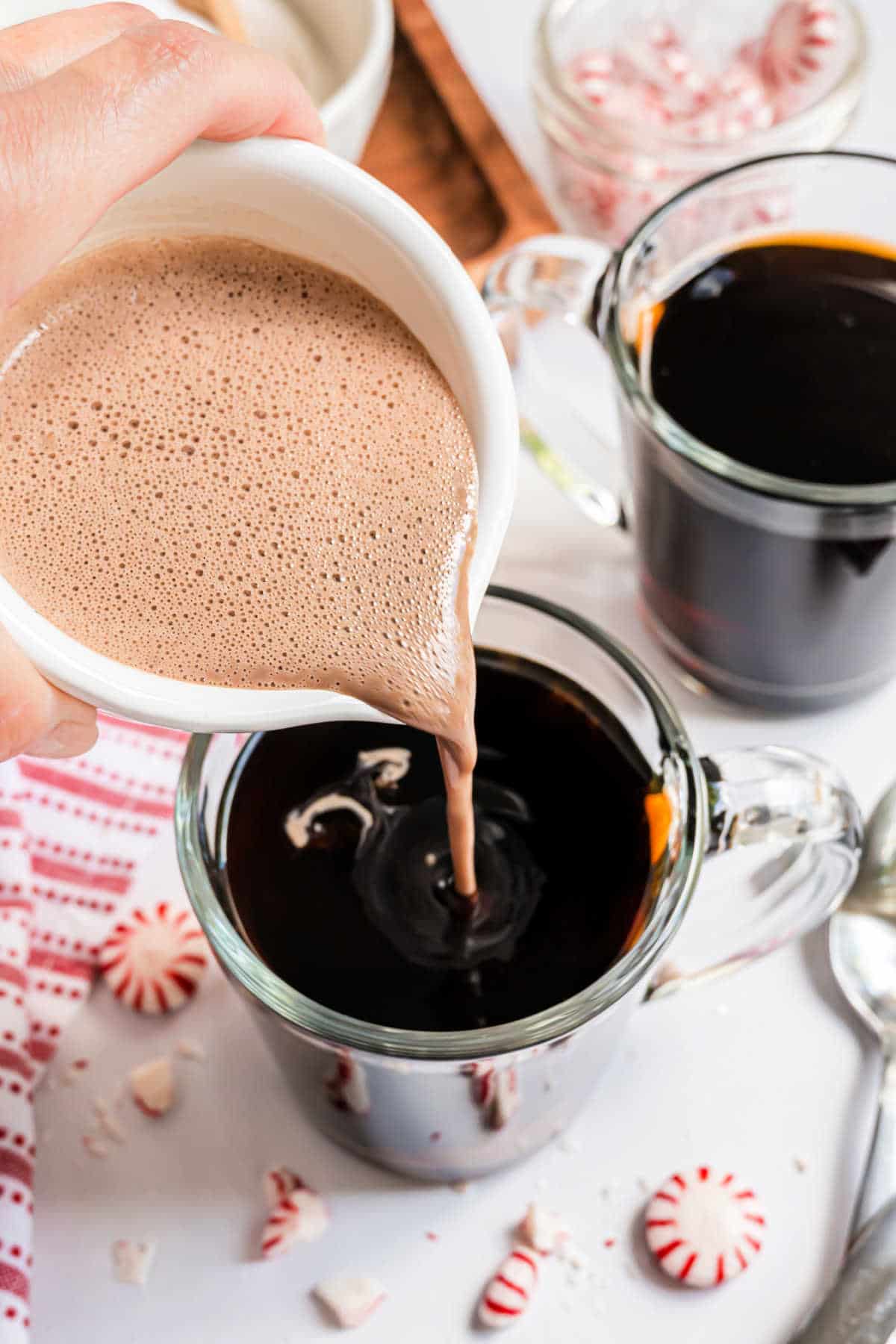 Homemade creamer being poured into a mug of hot cocoa.
