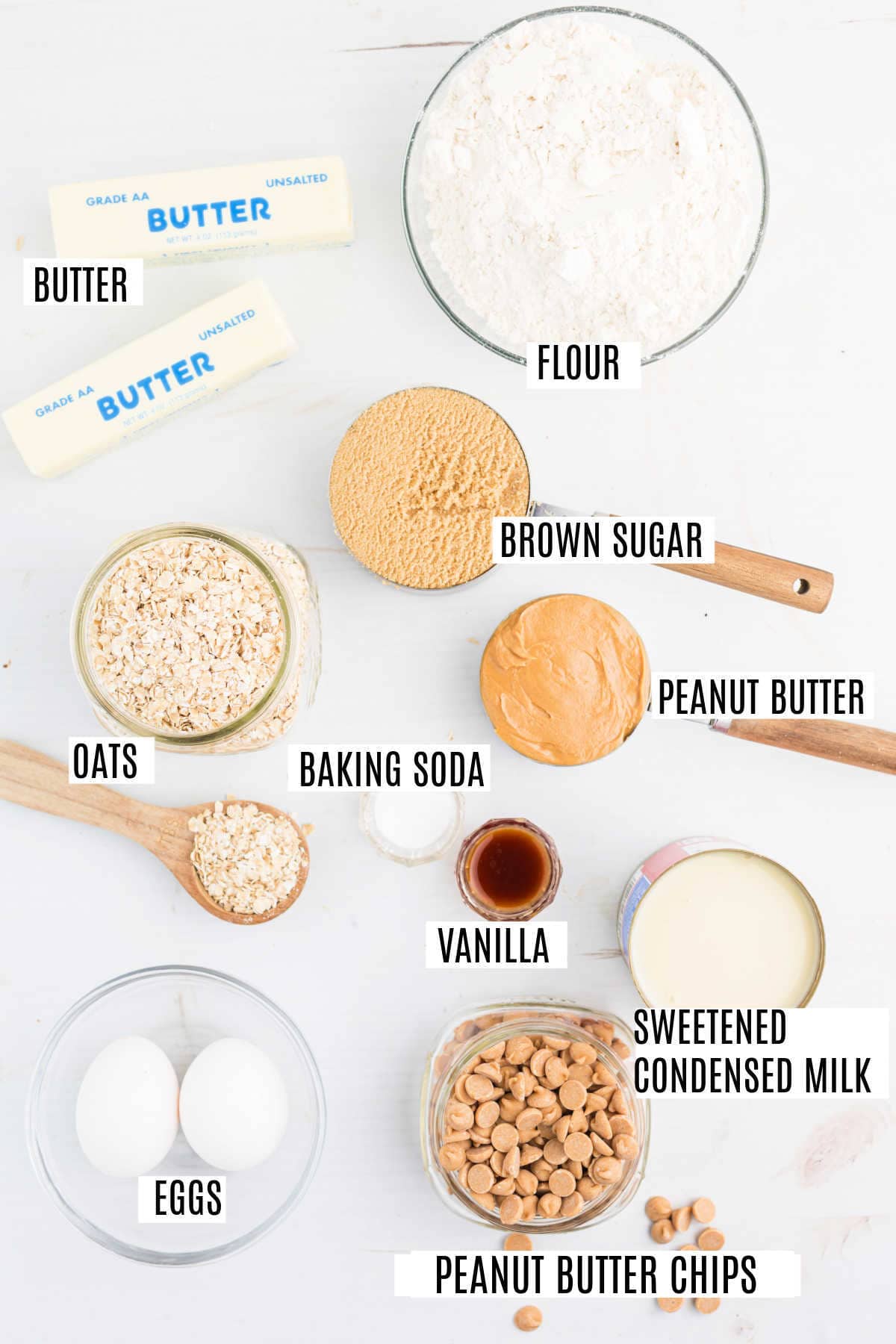 Labeled baking ingredients including butter, flour, brown sugar, oats, baking soda, vanilla, eggs, and peanut butter—perfect for making delicious peanut butter revel bars.