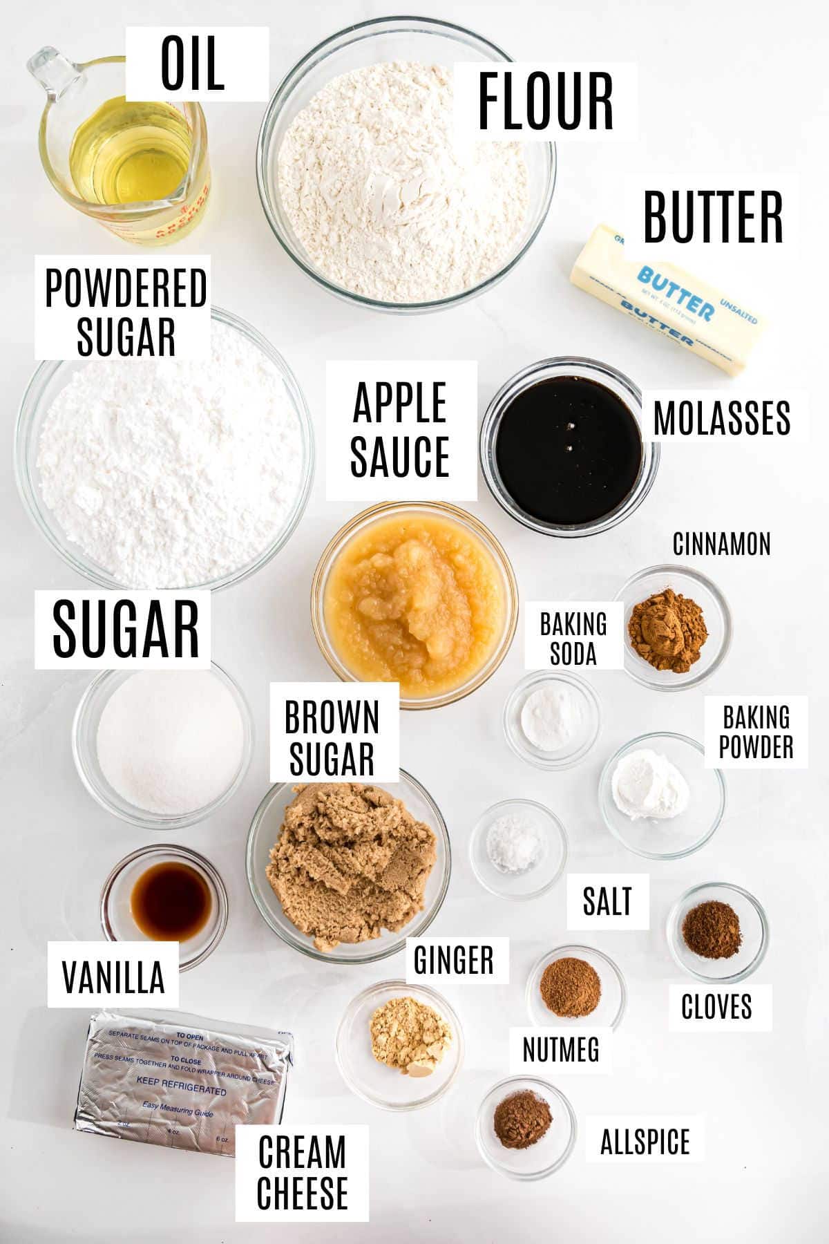 Labeled baking ingredients in bowls: flour, sugars, oil, butter, applesauce, spices, baking soda, cream cheese, vanilla.