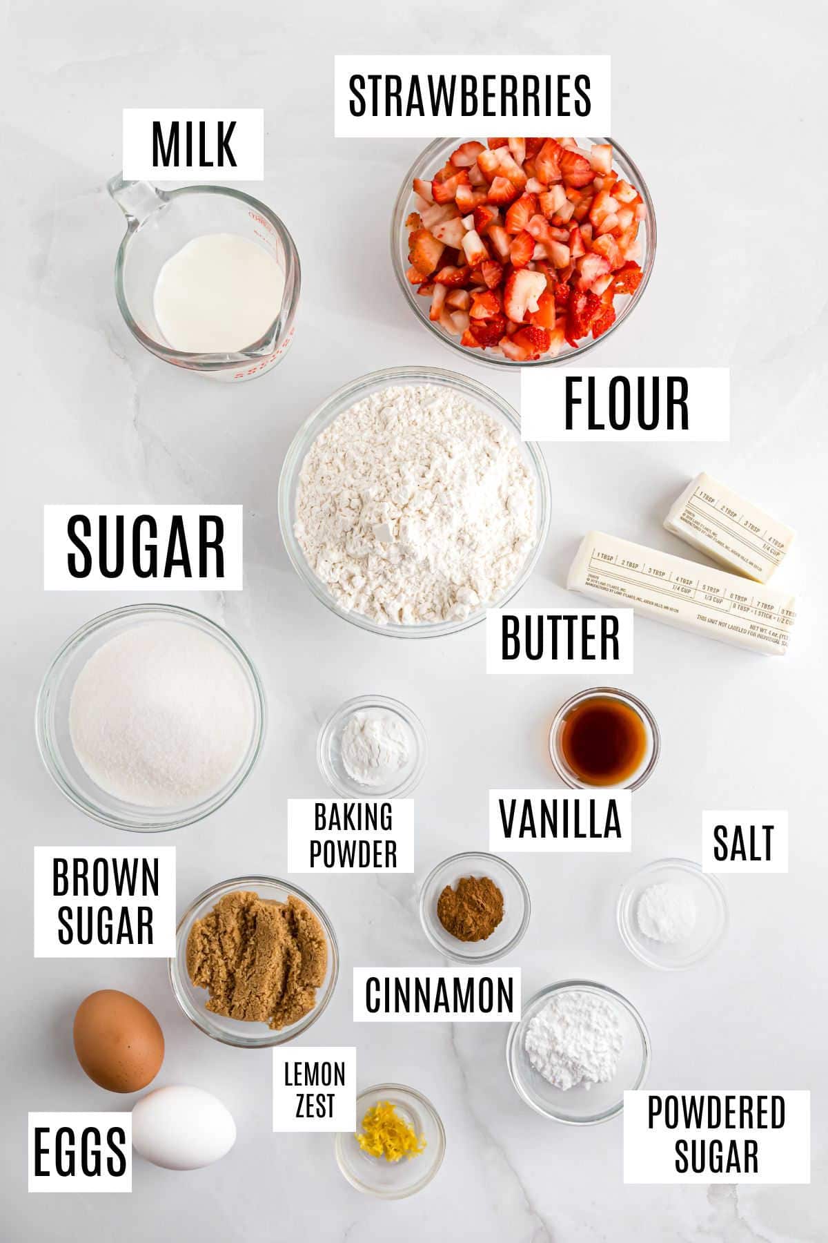 Labeled ingredients for baking: milk, strawberries, flour, butter, sugar, brown sugar, eggs, spices, and vanilla.