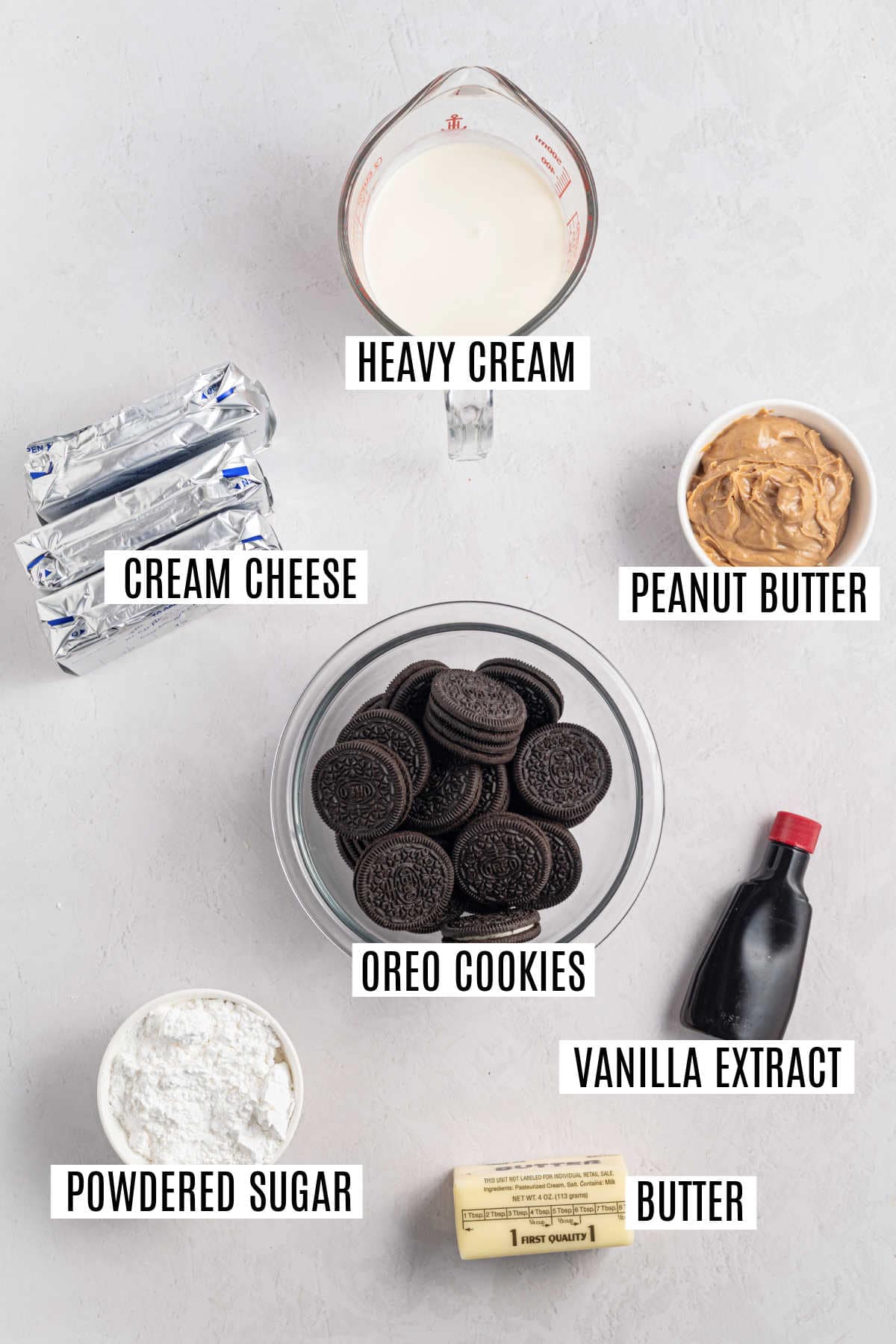 Labeled ingredients for a dessert: cream cheese, heavy cream, peanut butter, Oreo cookies, vanilla, sugar, butter.