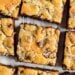 Chocolate chip peanut butter swirled cookie bars on a parchment paper lined baking sheet.